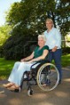 /album/galerie-photos/a10582315-infirmiere-souriant-conduite-haute-femme-en-fauteuil-roulant-a-travers-le-parc-jpg/